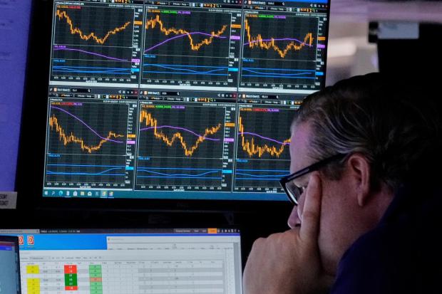 Specialist Gregg Maloney works at his post on the floor of the New York Stock Exchange